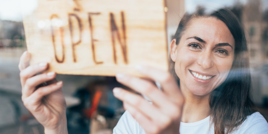 Woman holding open sign